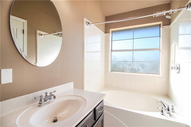 bathroom with a bathing tub, plenty of natural light, and vanity