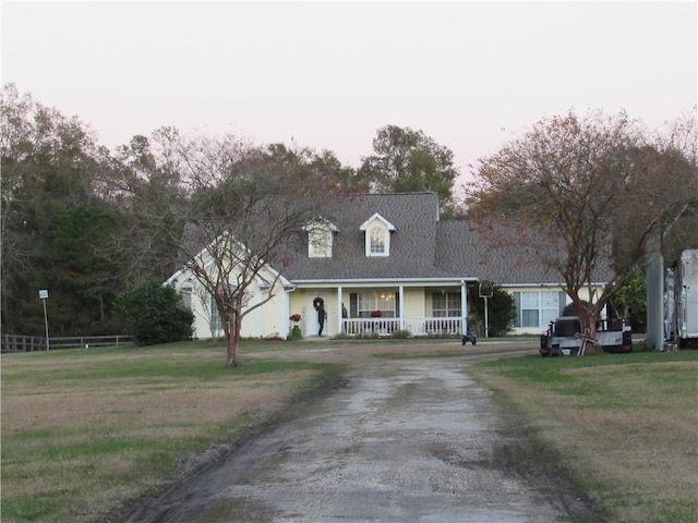 cape cod home with a front lawn and a porch