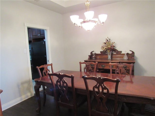 dining room with hardwood / wood-style flooring and a notable chandelier