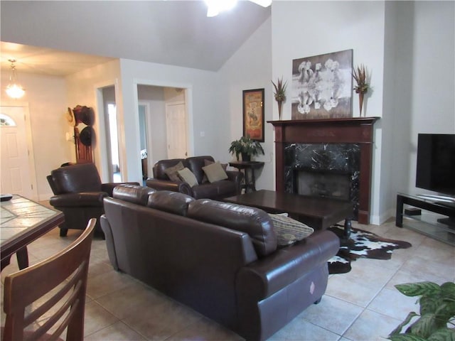 tiled living room with a high end fireplace, a chandelier, and vaulted ceiling