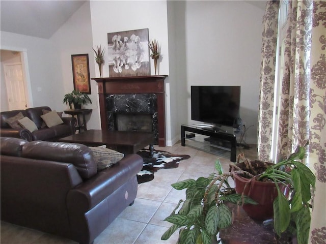 living room featuring light tile patterned floors, vaulted ceiling, and a premium fireplace