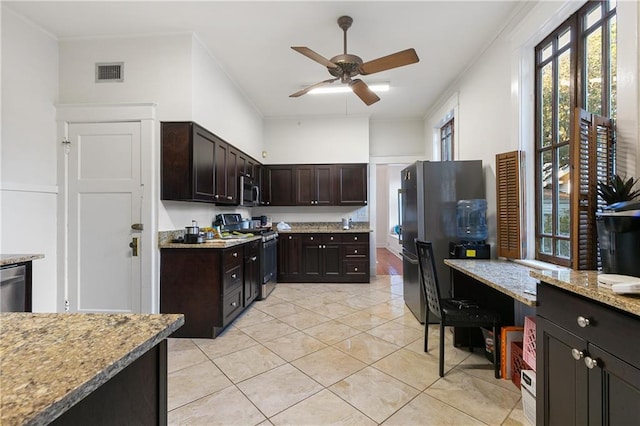 kitchen with dark brown cabinets, light stone counters, ornamental molding, and stainless steel appliances