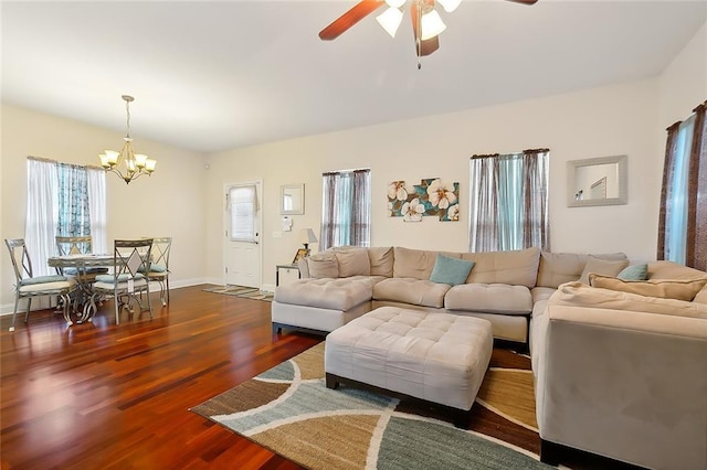 living room featuring ceiling fan with notable chandelier and dark hardwood / wood-style flooring