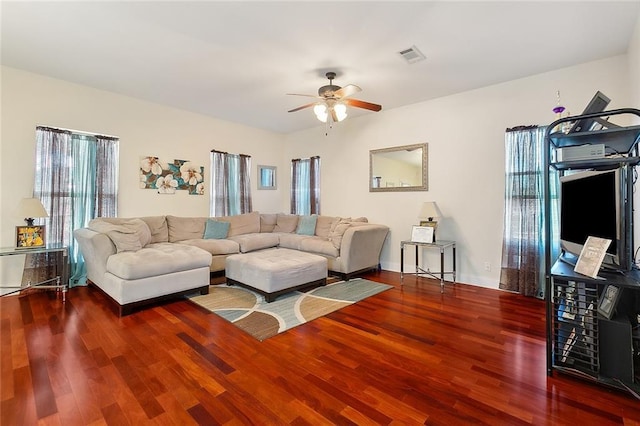 living room with ceiling fan and dark wood-type flooring