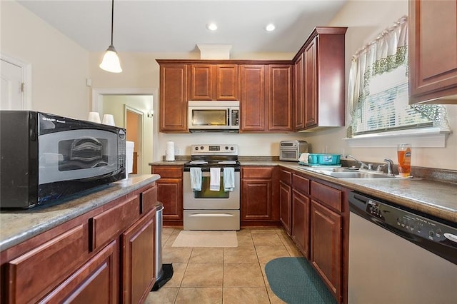 kitchen featuring pendant lighting, stainless steel appliances, light tile patterned floors, and sink