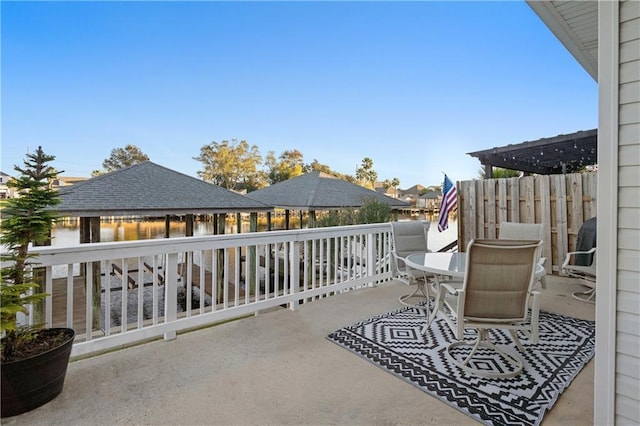 view of patio with a pergola and a water view