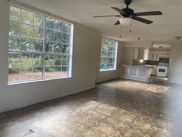 unfurnished living room with a textured ceiling and ceiling fan