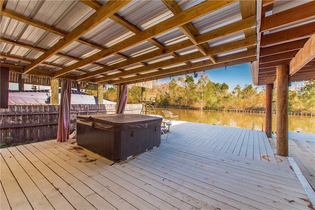 view of dock with a deck with water view and a hot tub