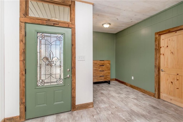 foyer entrance featuring hardwood / wood-style floors and wood walls