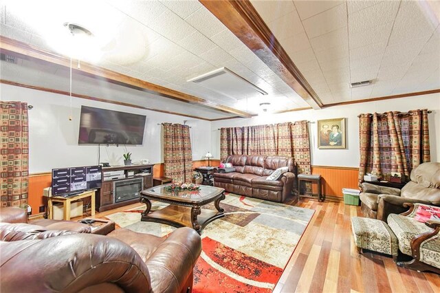 living room with hardwood / wood-style flooring, crown molding, and wooden walls