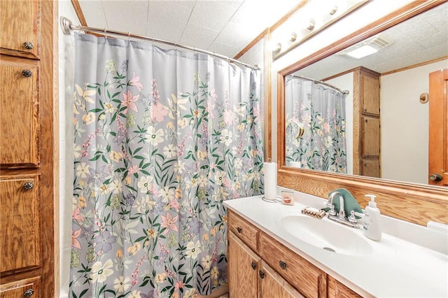 bathroom with vanity, curtained shower, and a textured ceiling