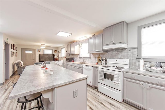 kitchen featuring white appliances, light hardwood / wood-style flooring, and plenty of natural light