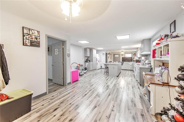 living room with ceiling fan and light hardwood / wood-style floors