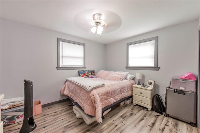 bedroom with light wood-type flooring, multiple windows, and ceiling fan