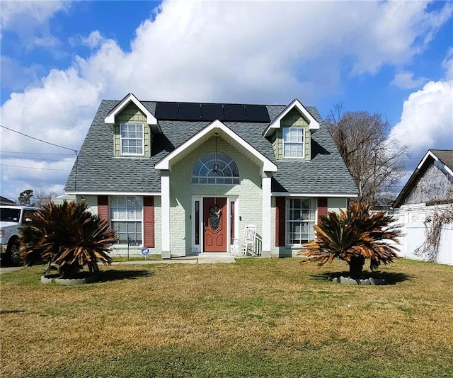 view of front facade with a front lawn and solar panels