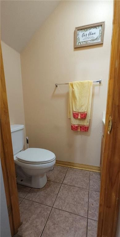 bathroom with tile patterned floors, toilet, and vaulted ceiling