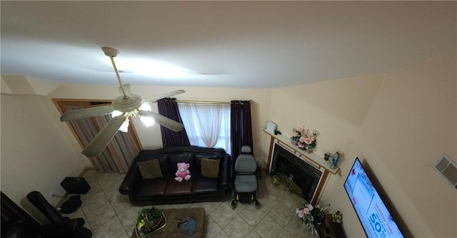 living room with ceiling fan and a fireplace