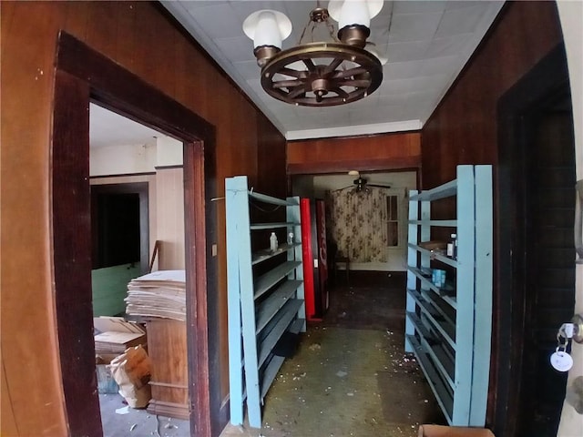 interior space featuring a chandelier and wood walls