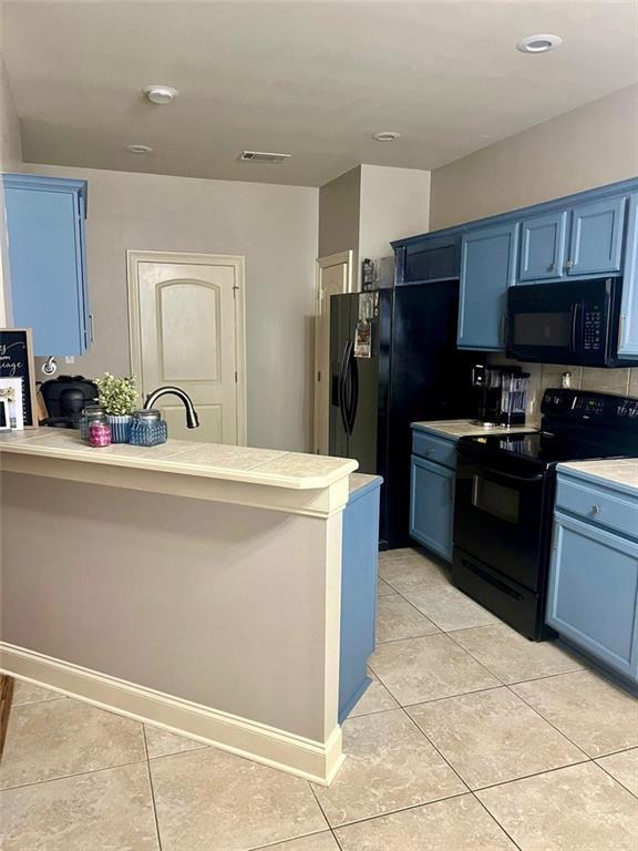 kitchen with blue cabinetry and black appliances