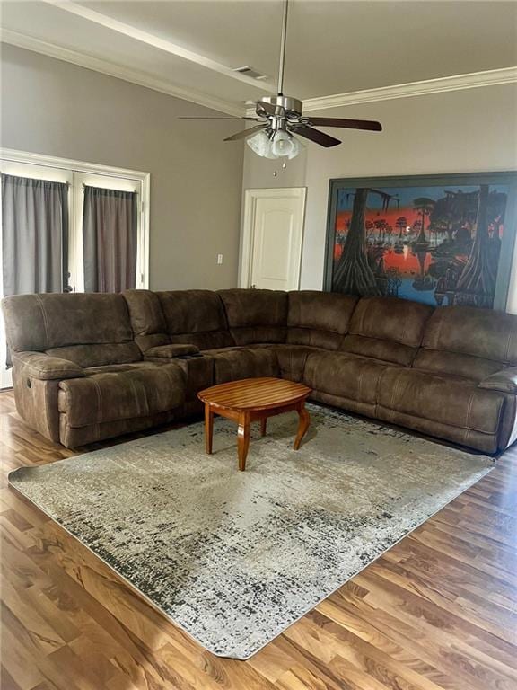 living area featuring ceiling fan, crown molding, and wood finished floors