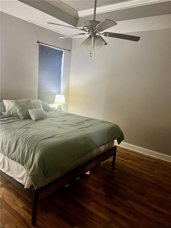 bedroom with crown molding, ceiling fan, baseboards, and wood finished floors