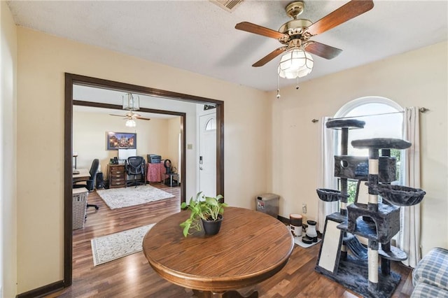 dining area with wood-type flooring and ceiling fan