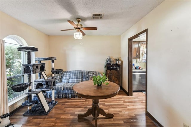 exercise room with hardwood / wood-style floors, ceiling fan, a healthy amount of sunlight, and a textured ceiling