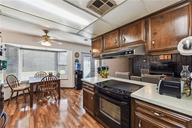 kitchen with ceiling fan, black electric range, a healthy amount of sunlight, and wood-type flooring