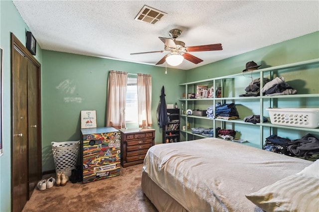 bedroom featuring carpet, ceiling fan, a textured ceiling, and a closet