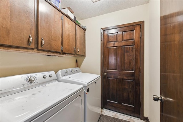 laundry area featuring washer and dryer, a textured ceiling, cabinets, and light tile patterned flooring