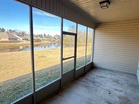 unfurnished sunroom featuring a water view