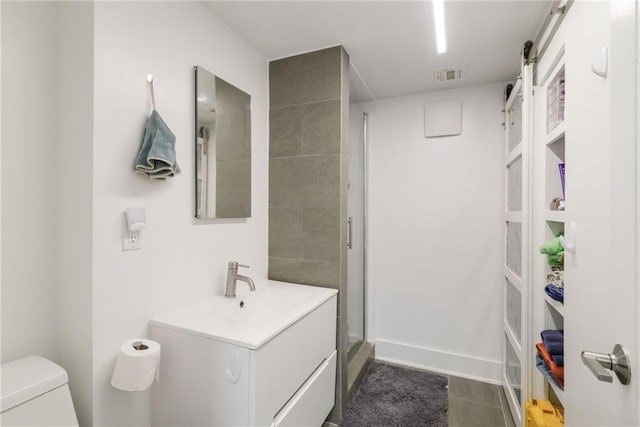 bathroom with tile patterned flooring, vanity, toilet, and walk in shower