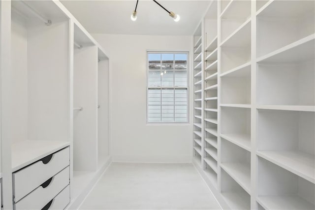 spacious closet with a chandelier