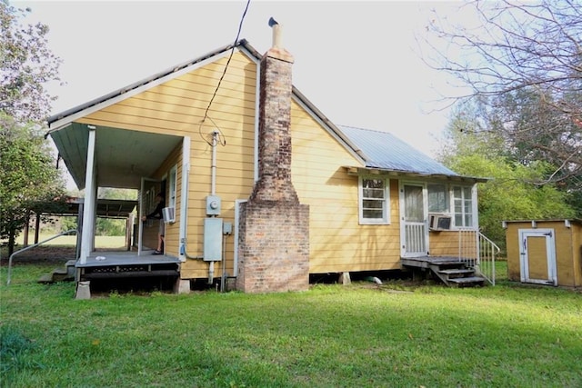 rear view of property with a yard and a shed