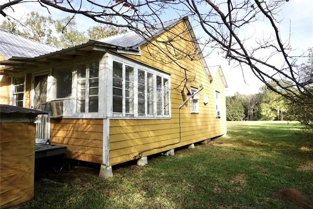 view of home's exterior with a lawn and a sunroom