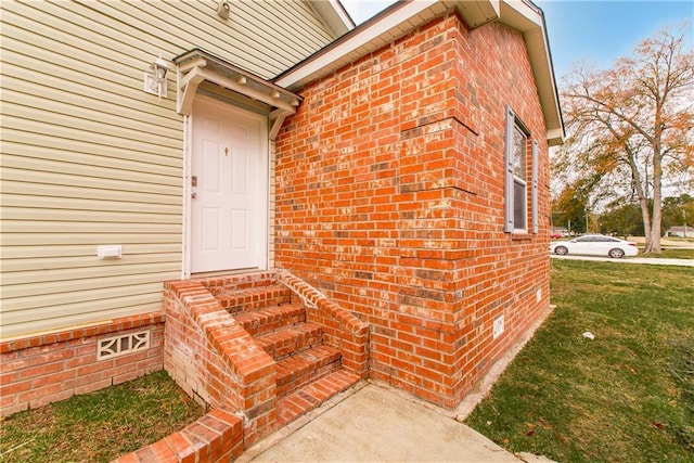 property entrance with a lawn