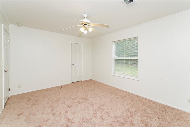 carpeted empty room with ceiling fan and ornamental molding