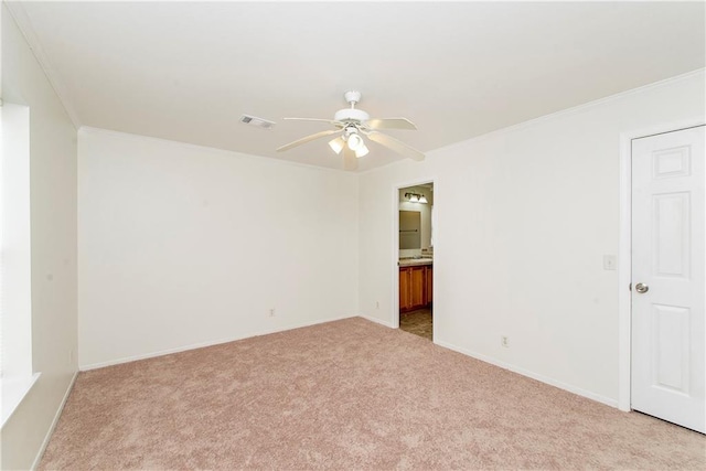 unfurnished room with ceiling fan, light colored carpet, and ornamental molding