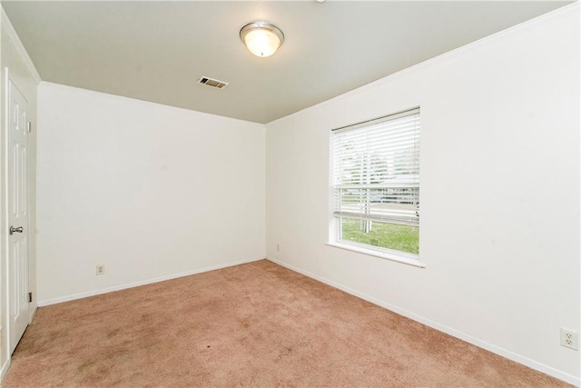 empty room featuring light carpet and crown molding