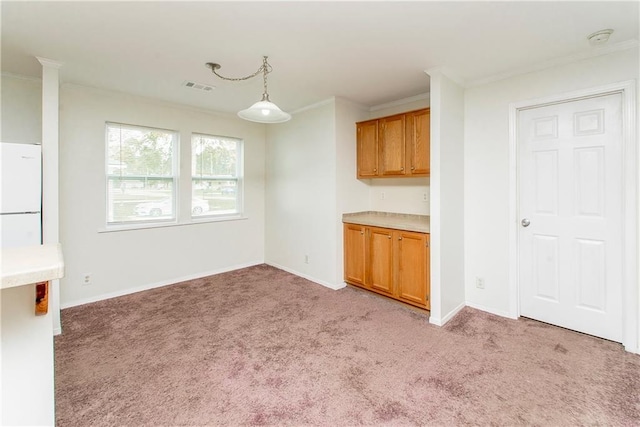 unfurnished dining area featuring light colored carpet and ornamental molding