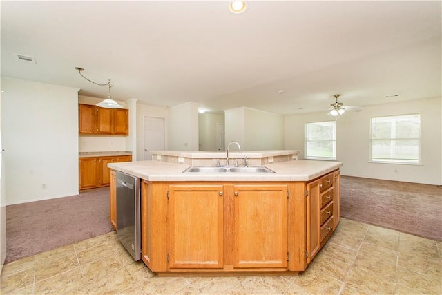 kitchen featuring ceiling fan, dishwasher, sink, an island with sink, and light carpet