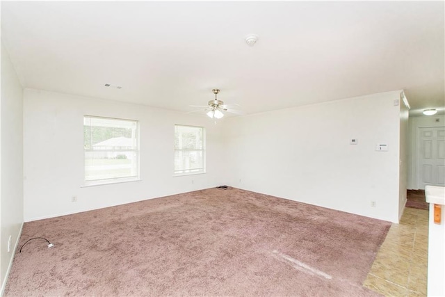 unfurnished room featuring ceiling fan and carpet