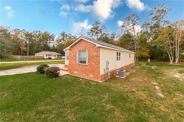 view of property exterior with a lawn and central air condition unit