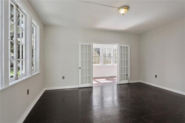 empty room with dark wood-type flooring and french doors