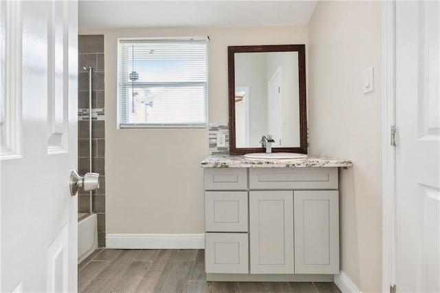 bathroom with vanity, wood-type flooring, and tiled shower / bath combo