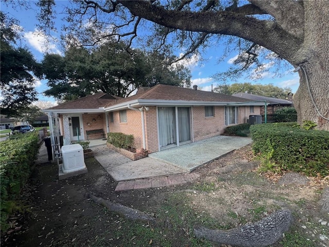 back of property featuring central air condition unit and a patio