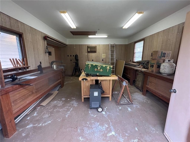 misc room with a workshop area, a wealth of natural light, and wooden walls