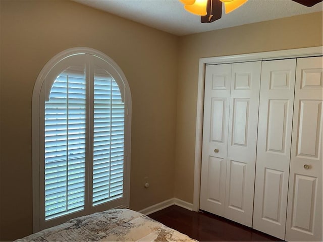 bedroom with ceiling fan, dark hardwood / wood-style floors, and a closet