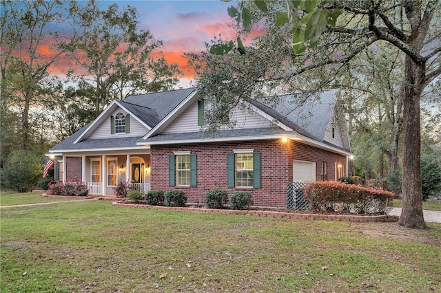 view of front facade featuring a yard, a porch, and a garage