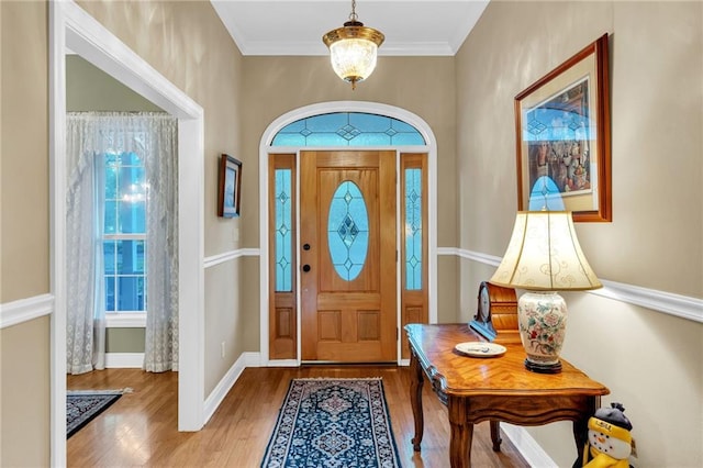 foyer featuring crown molding and hardwood / wood-style floors